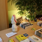 Table avec des brochures FRAGILE et une statue