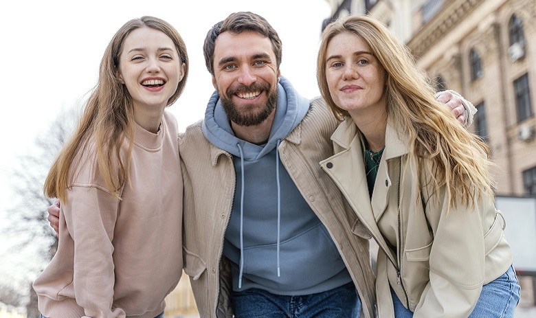 Deux femmes et un homme se tenant les uns à côtés des autres