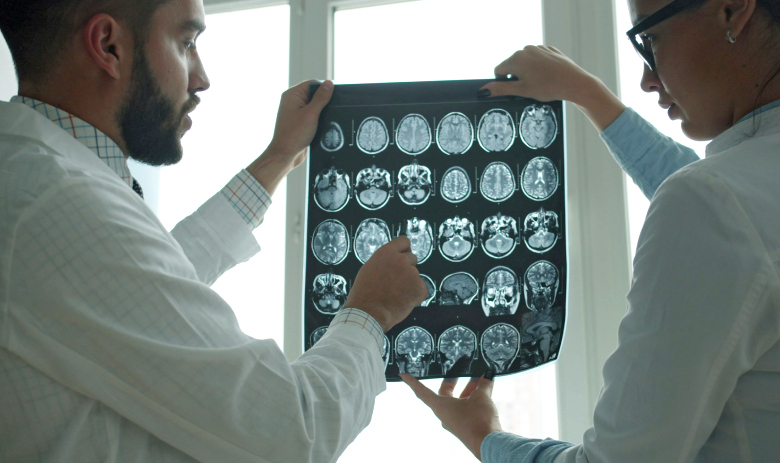 Deux professionnels de la santé examinent un scan du cerveau