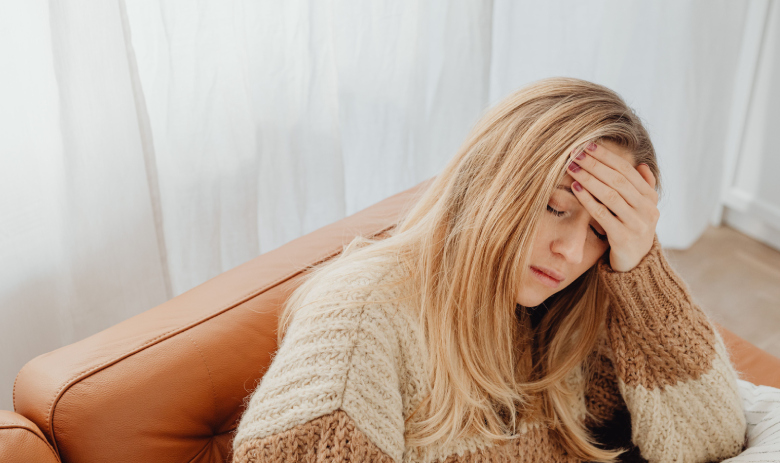 Une femme se tient la tête