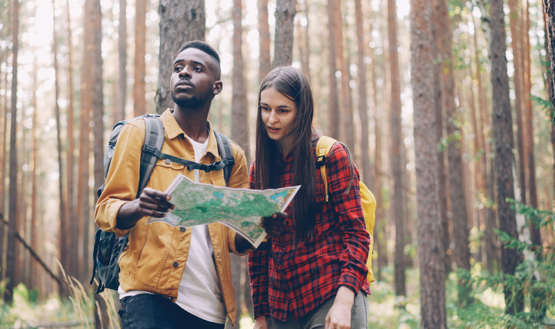 Deux personnes en forêt regardent une carte